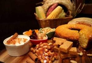 Uma mesa cheia de comidas típicas para organizar festa julina