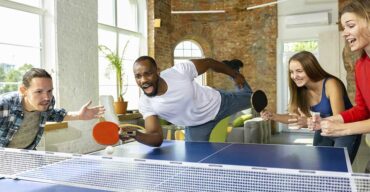 Amigos jogando tênis de mesa e exercitando os benefícios Do Ping Pong