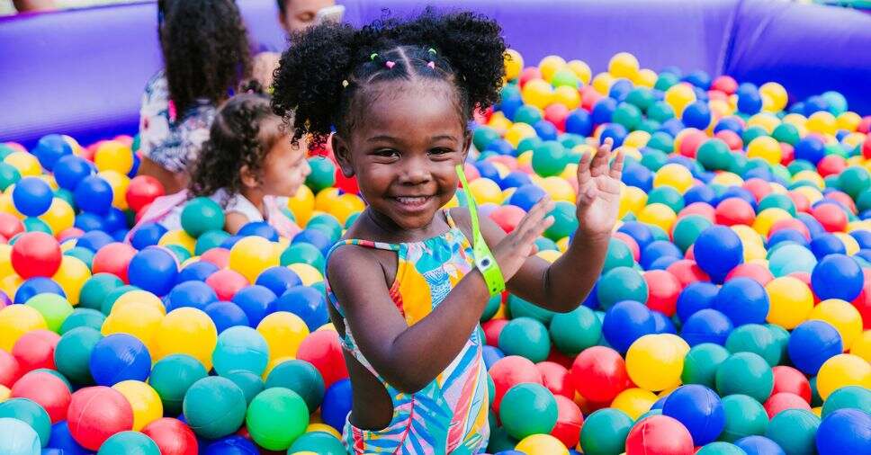 Menina brinca em cercado colorido, uma opção de brinquedos infláveis para espaços pequenos